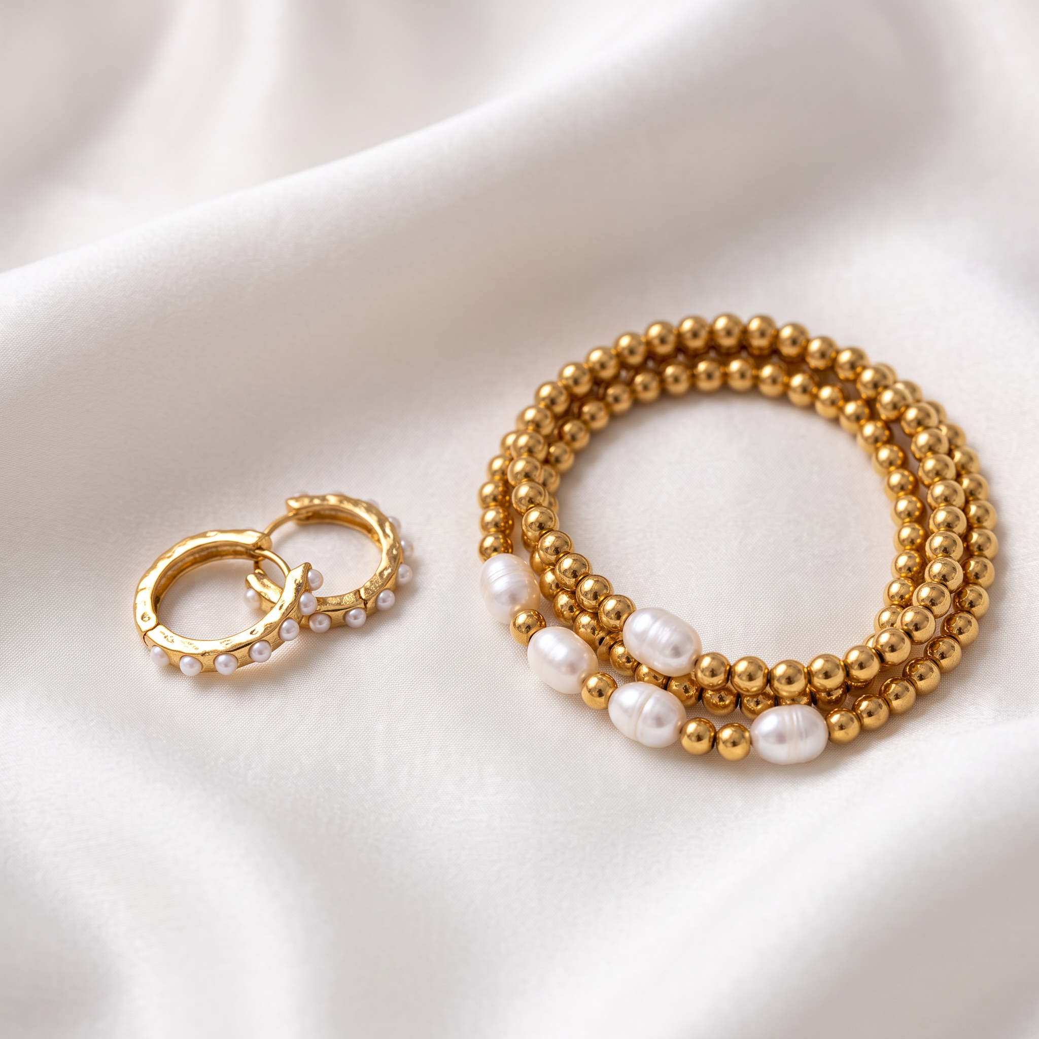 The Pearl Duo — pearl huggies and bracelet on white silk